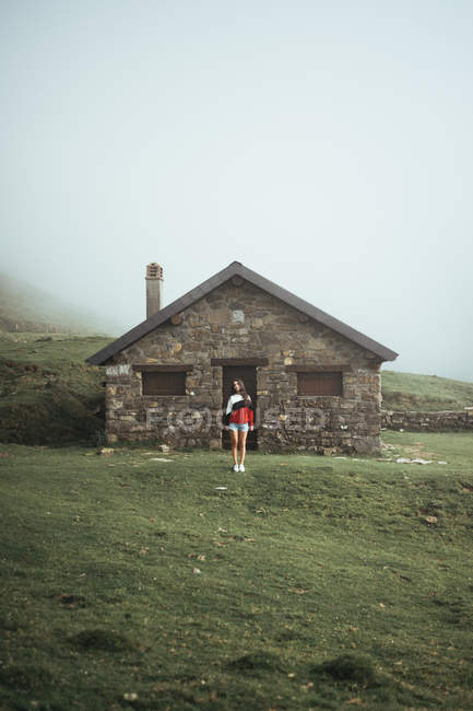 Woman standing at rural house — Stock Photo