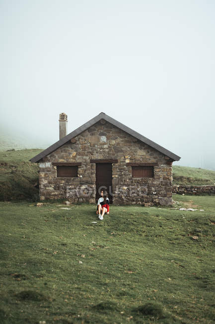 Frau sitzt in ländlichem Haus — Stockfoto