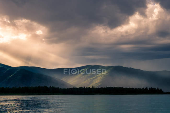 Зеленые горы при солнечном свете и озере — стоковое фото