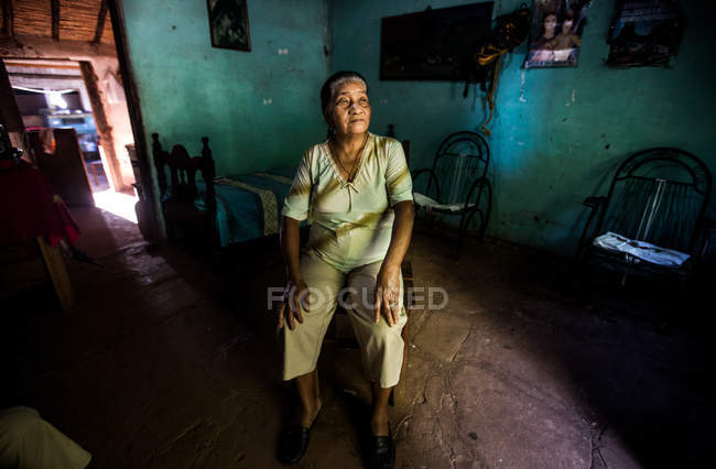 Senior mulher sentada na cadeira — Fotografia de Stock