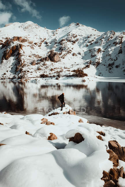 Persona en la orilla del lago nevado - foto de stock