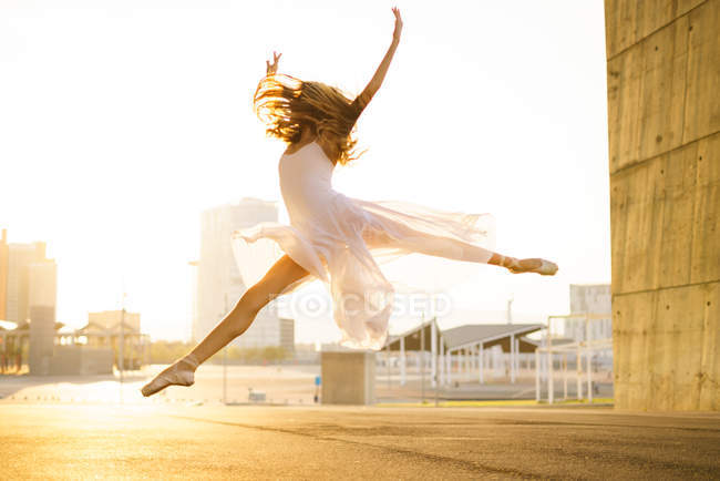 Vista lateral da jovem dançarina de balé realizando balé na cena urbana — Fotografia de Stock