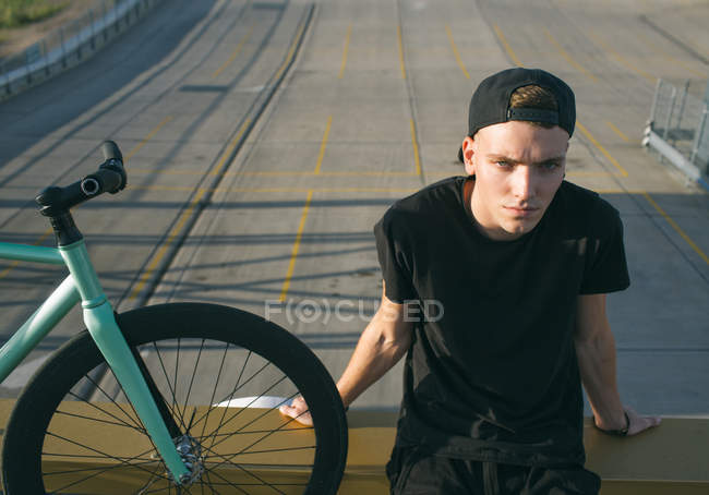 Boy sitting near bicycle — Stock Photo