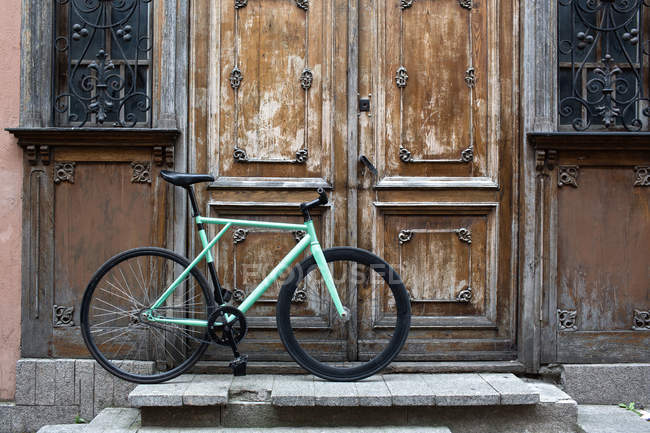 Bicycle parked on doorstep — Stock Photo
