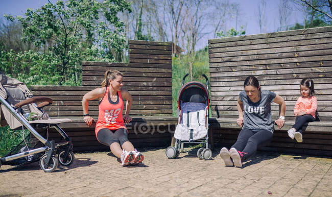 Madri forti e sane che si esercitano con il bambino nel parco — Foto stock