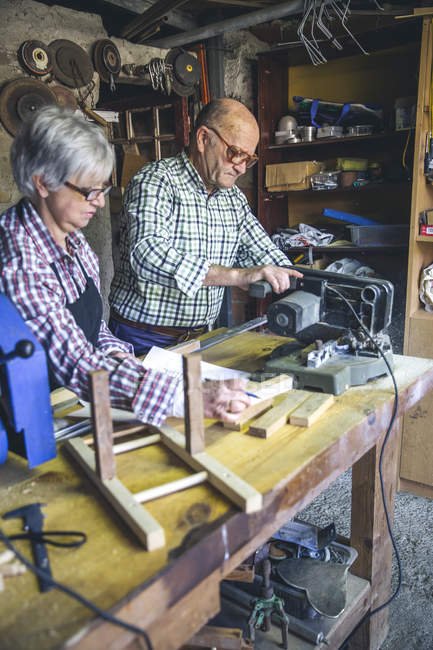Casal sénior trabalhando na oficina de carpinteiro — Fotografia de Stock