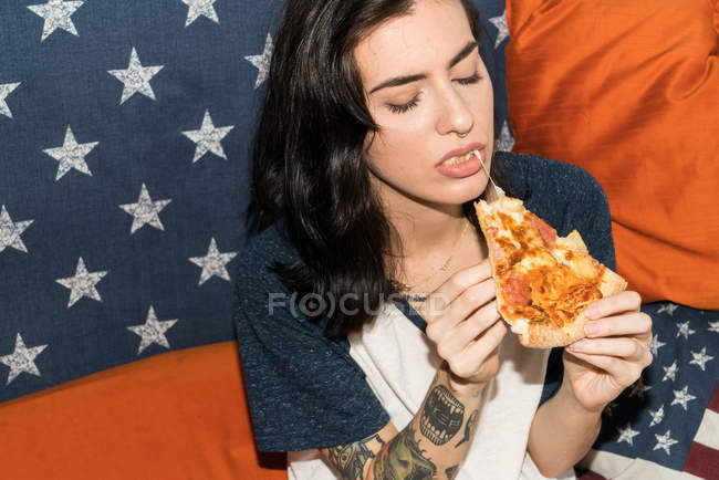 Jeune jolie fille manger de la pizza — Photo de stock