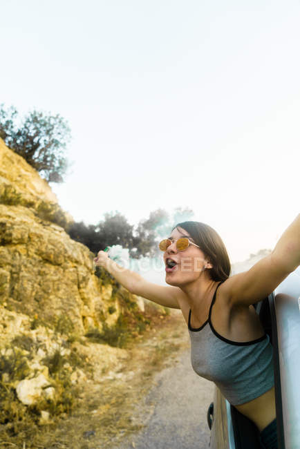 Excited woman shouting in car window — Stock Photo