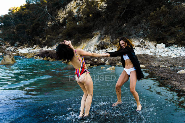 Meninas alegres brincando na água — Fotografia de Stock