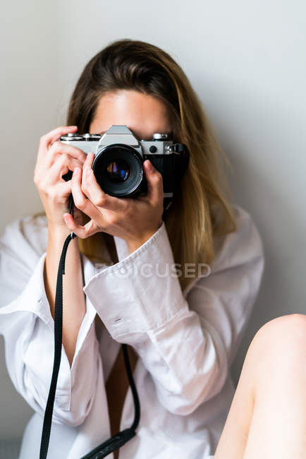 Молодая женщина, прицеливающаяся камерой — стоковое фото