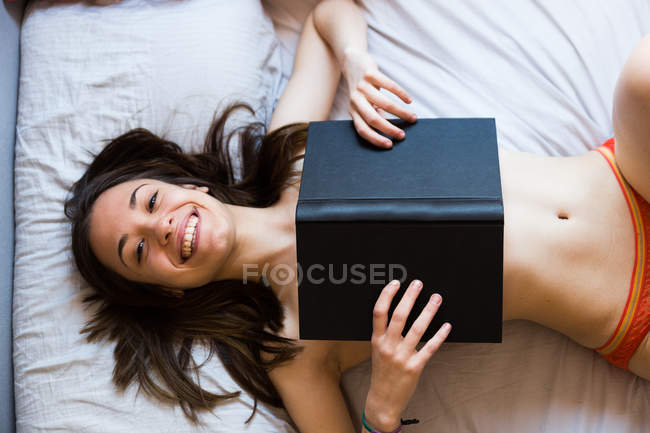 Riéndose topless chica cubriendo con libro - foto de stock