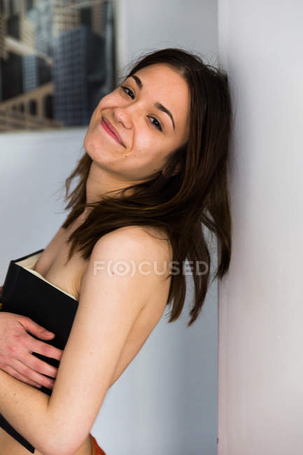 Smiling girl covering bust with book — Stock Photo