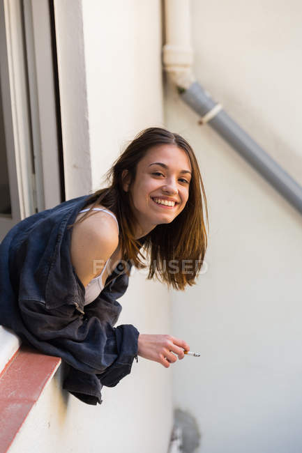 Menina adorável fumar na janela — Fotografia de Stock