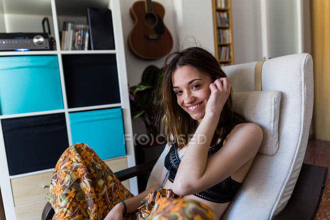 Smiling girl at home in armchair — Stock Photo