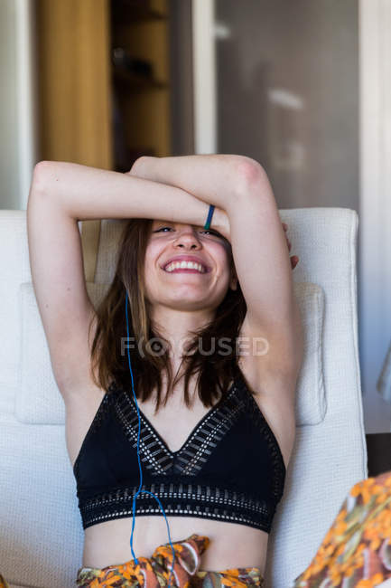 Rindo menina posando em poltrona — Fotografia de Stock