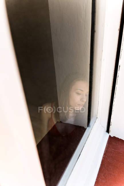 Mädchen in Dessous hinter dem Fenster — Stockfoto