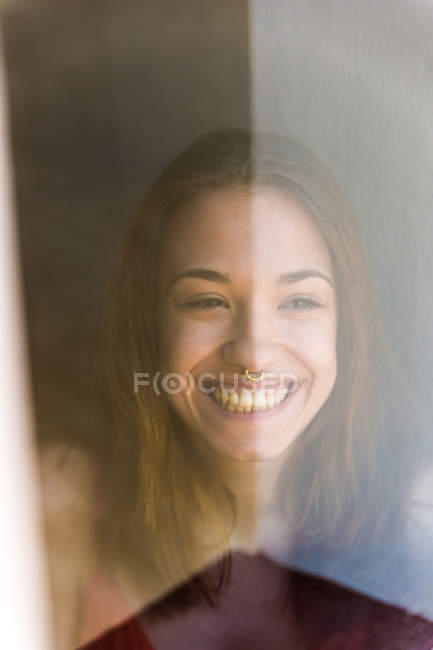 Смеющаяся девушка сквозь стекло — стоковое фото