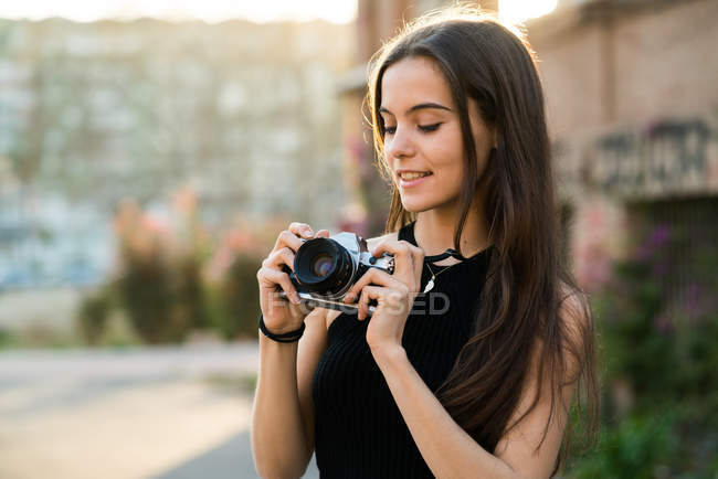 Hübsche Frau, die eine Kamera einsetzt — Stockfoto