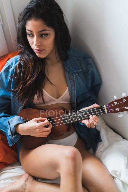 Женщина играет на укулеле — стоковое фото