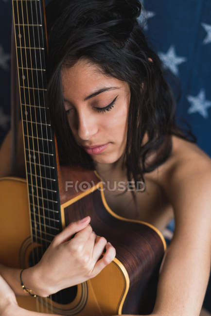 Morena feminino sentado com guitarra — Fotografia de Stock