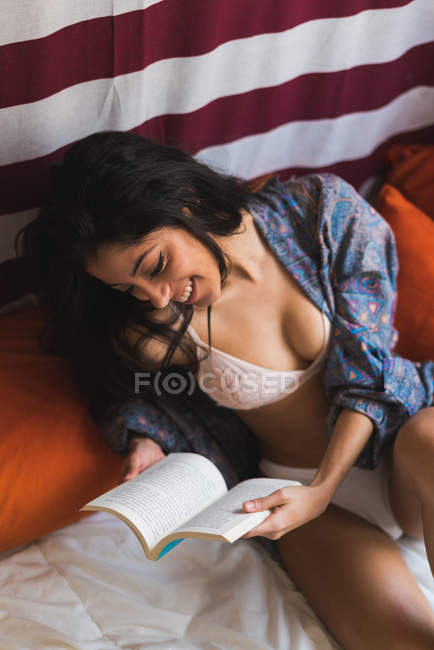 Livre de lecture féminin souriant — Photo de stock