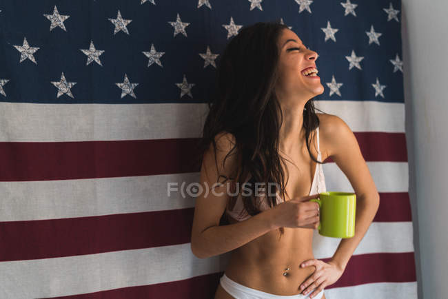 Femme avec tasse sur fond drapeau américain — Photo de stock