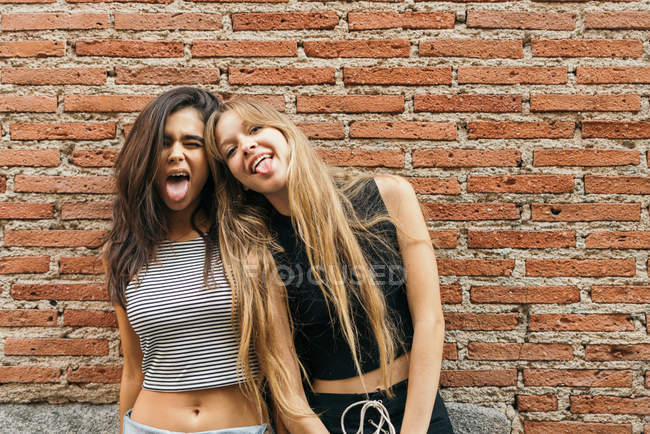 Laughing girlfriends on yellow — Stock Photo