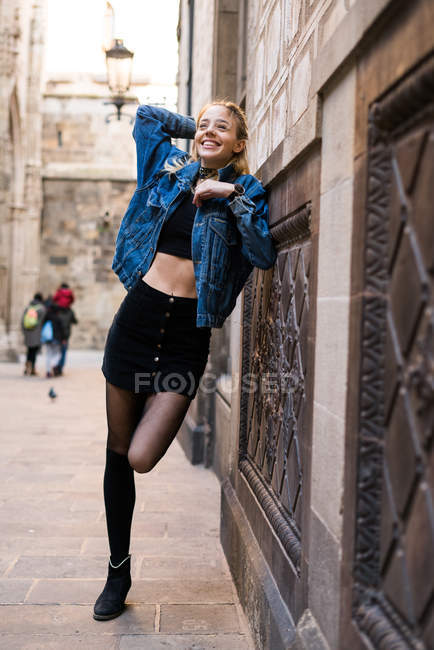 Lachende Frau posiert in der Nähe der Mauer — Stockfoto