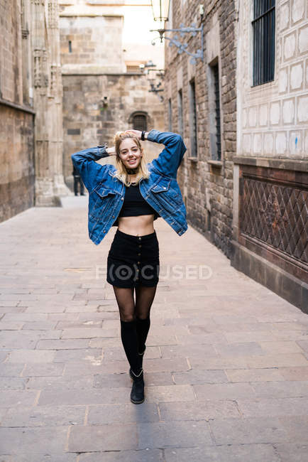 Smiling woman holding head in city — Stock Photo