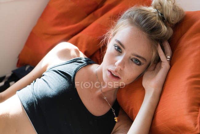 Young woman laying and holding head — Stock Photo