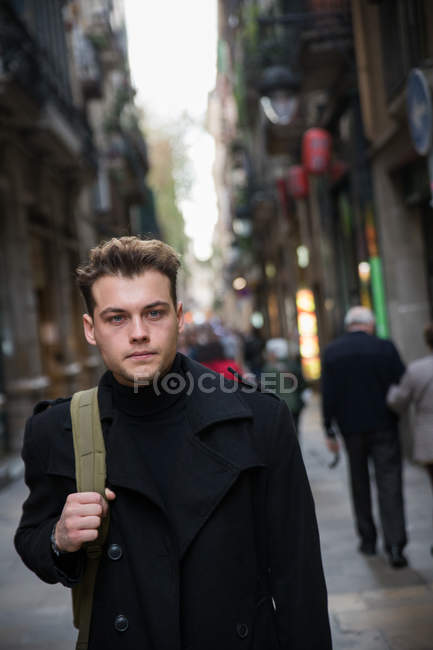 Jeune homme tenant sac à dos — Photo de stock