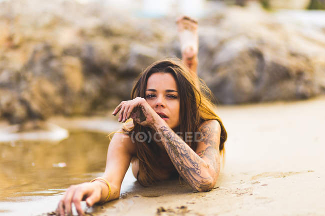Mujer rubia en topless en la playa - foto de stock