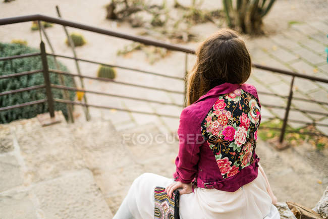 Jeune femme assise sur les escaliers — Photo de stock