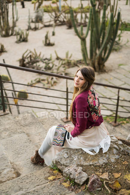 Молодая женщина, сидящая на лестнице — стоковое фото