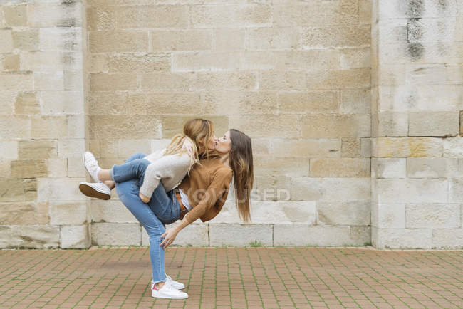 Mujeres abrazándose y besándose - foto de stock