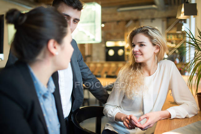 Side view of young colleagues working with laptop in modern office. — Stock Photo