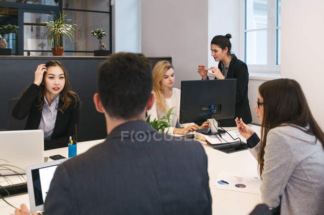 Jovens colegas brainstorming à mesa no escritório — Fotografia de Stock