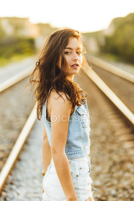 Девушка в джинсе оглядывается через плечо — стоковое фото