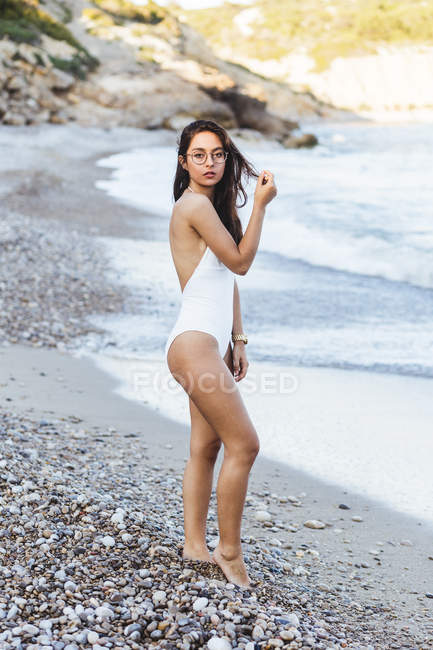 Ragazza in costume da bagno in posa sulla riva del mare — Foto stock