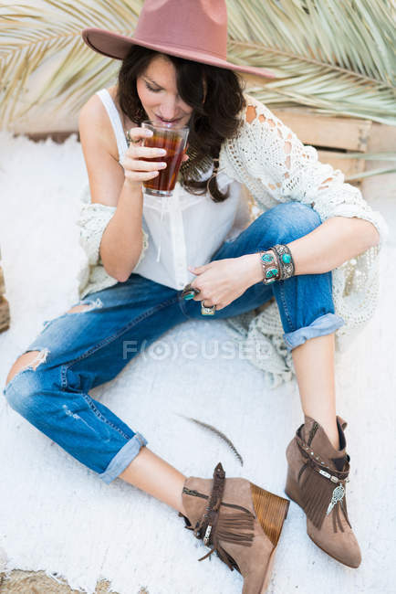 Женщина в стильном наряде с чаем — стоковое фото