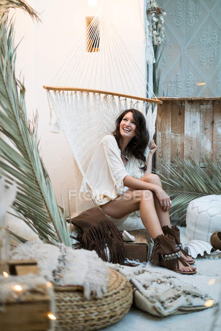 Веселая молодая женщина в веревочном кресле — стоковое фото
