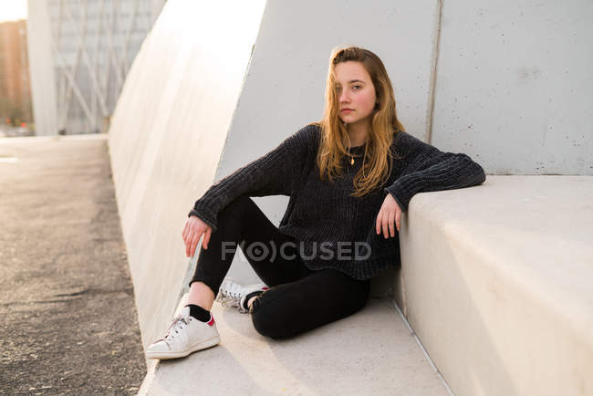 Young girl on concrete stairs — Stock Photo