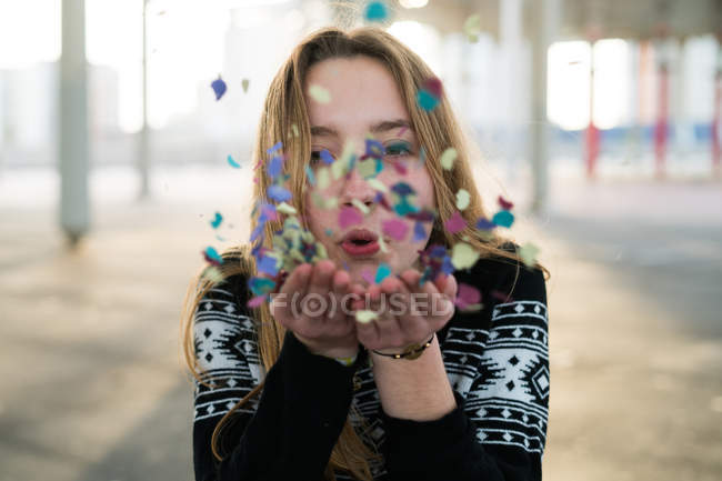 Mulher soprando confete — Fotografia de Stock
