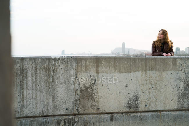 Молода дівчина біля бетонного блоку — стокове фото