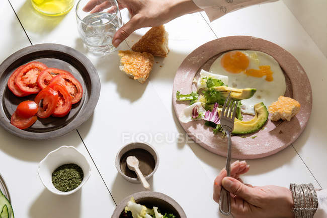 Donna che mangia uova e avocado — Foto stock