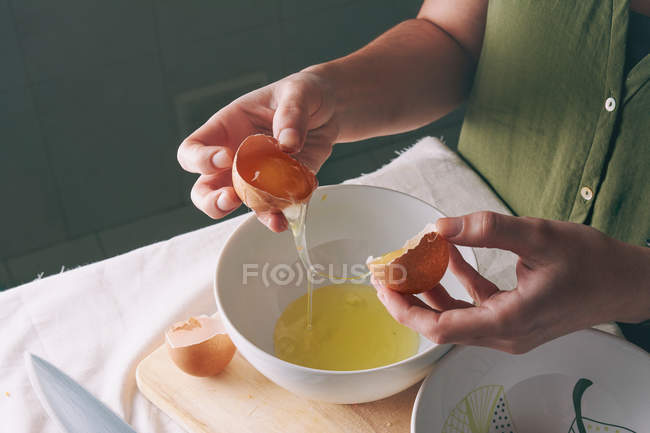 Женщина отделяет яичный желток — стоковое фото