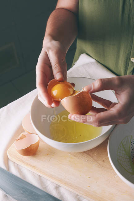 Woman separating egg yolk — Stock Photo