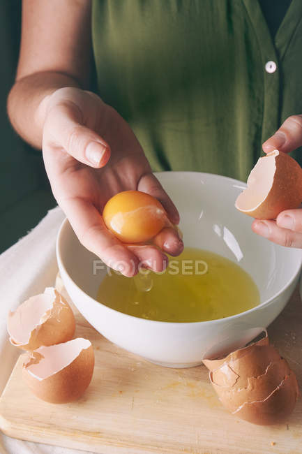 Женщина отделяет яичный желток — стоковое фото