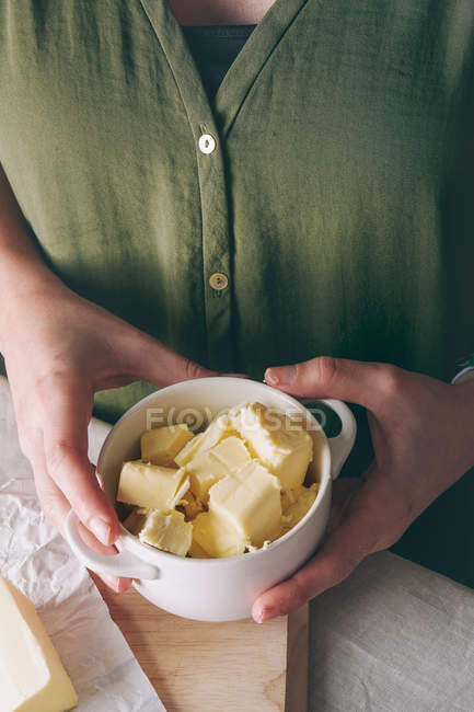 Mulher segurando manteiga cortada — Fotografia de Stock