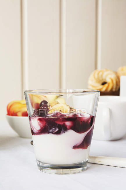 Vista laterale di vetro di yogurt con marmellata a tavola — Foto stock
